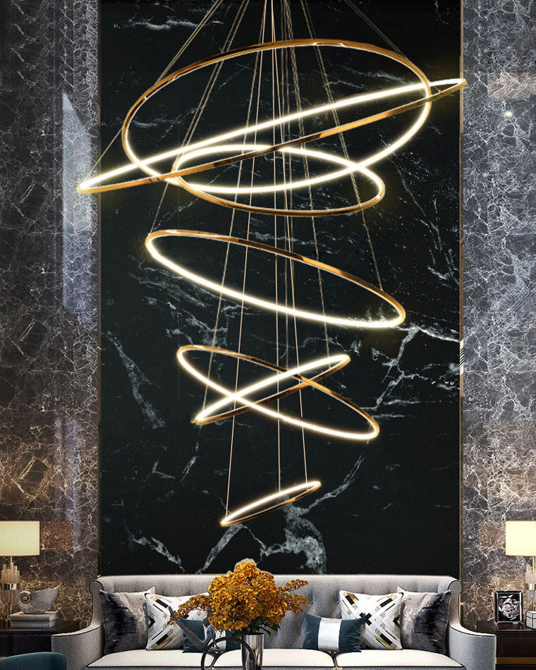 Glowing entryway chandelier against a dramatic black marble wall, turning an oversized vertical space into a luxurious first impression.