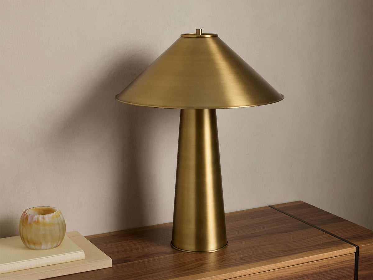 Front view of the brass Ombra Metal Table Lamp with an antiqued finish, featuring a conical shade and a tapered base.