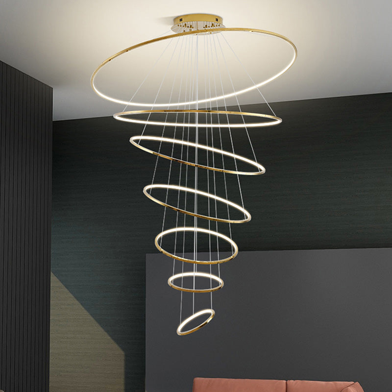 Seven-ring entryway chandelier glowing against a charcoal wall, creating dramatic height with a graceful, gradually narrowing silhouette.
