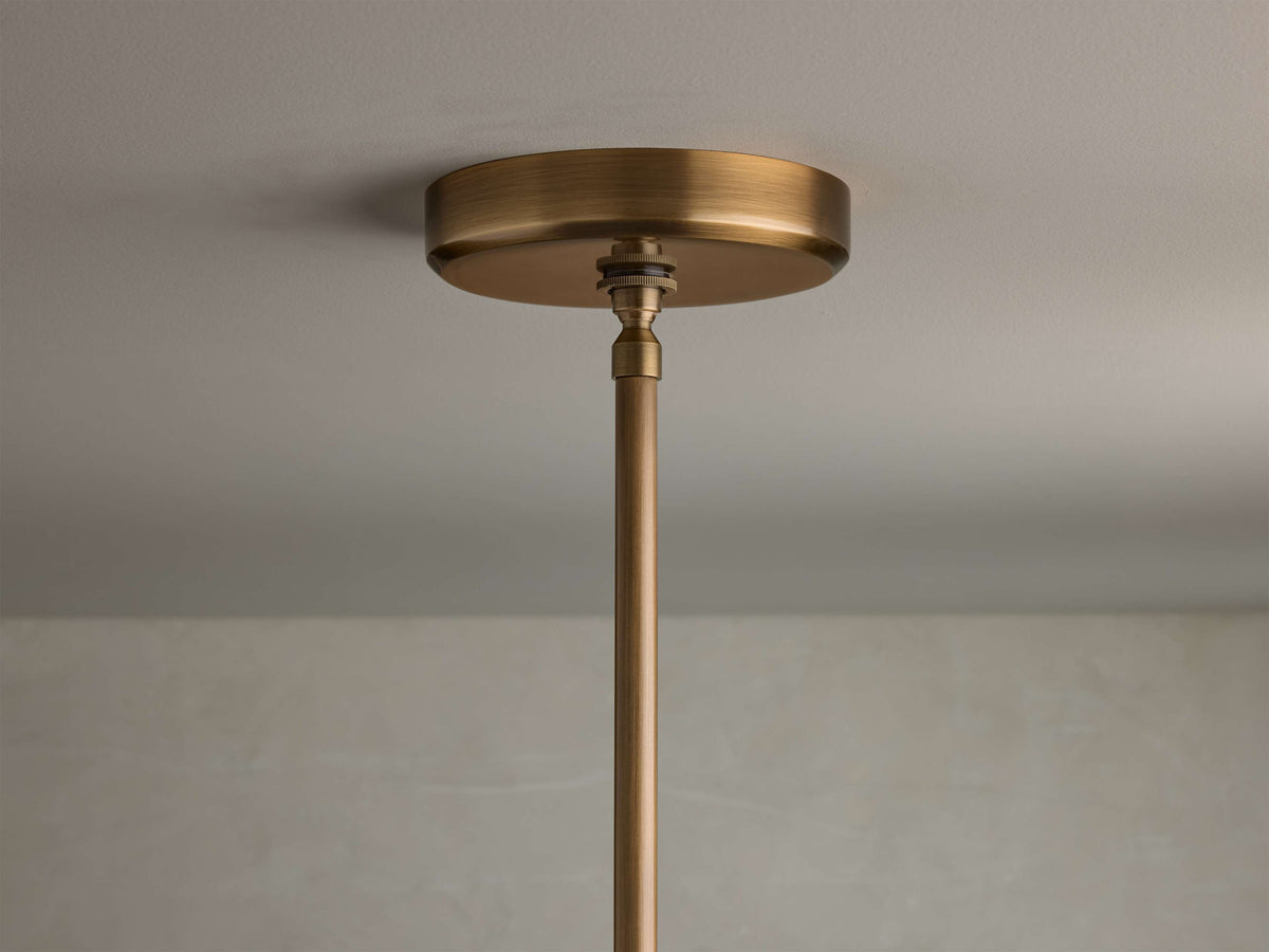 Close-up of the brass finish cylindrical ceiling canopy and hanging rod for the Edith Pendant.