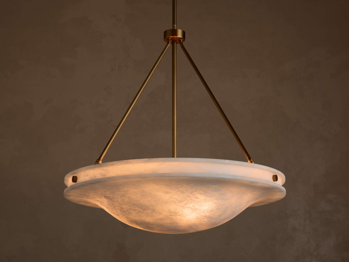 Front view of the Edith Pendant with an illuminated wavy alabaster stone shade and brass-finished suspension rods.