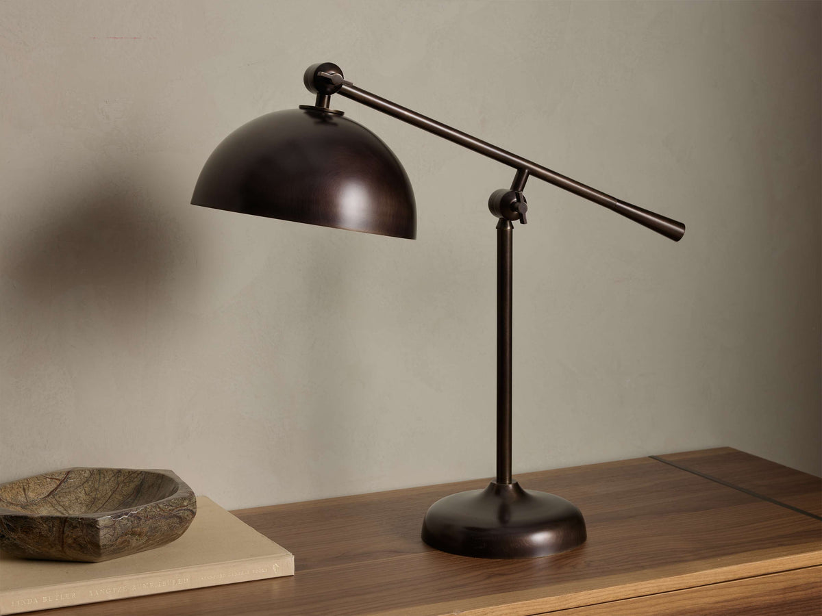 Front view of an oxidized antique brass Sigmund Task Table Lamp with a domed adjustable shade and pivoting arm.