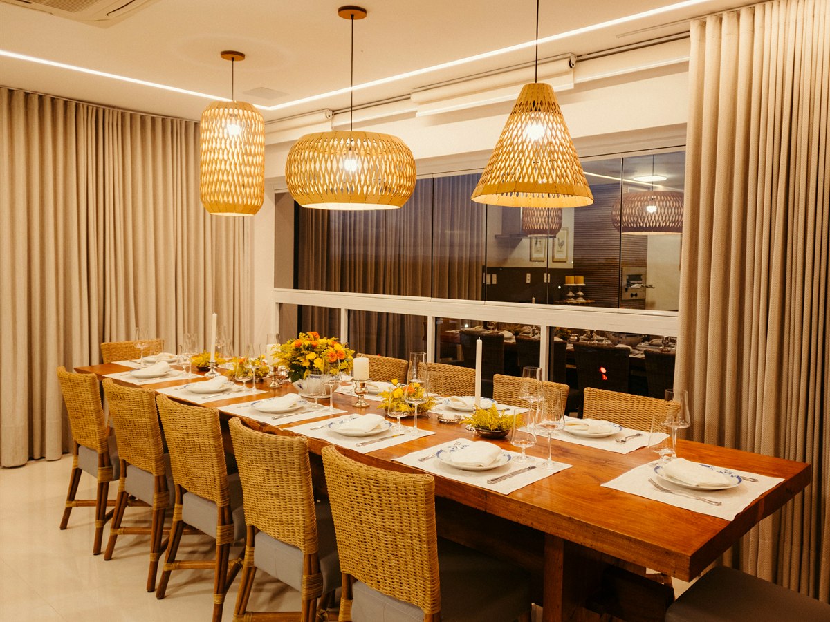 Three woven pendants above a long timber dining table
