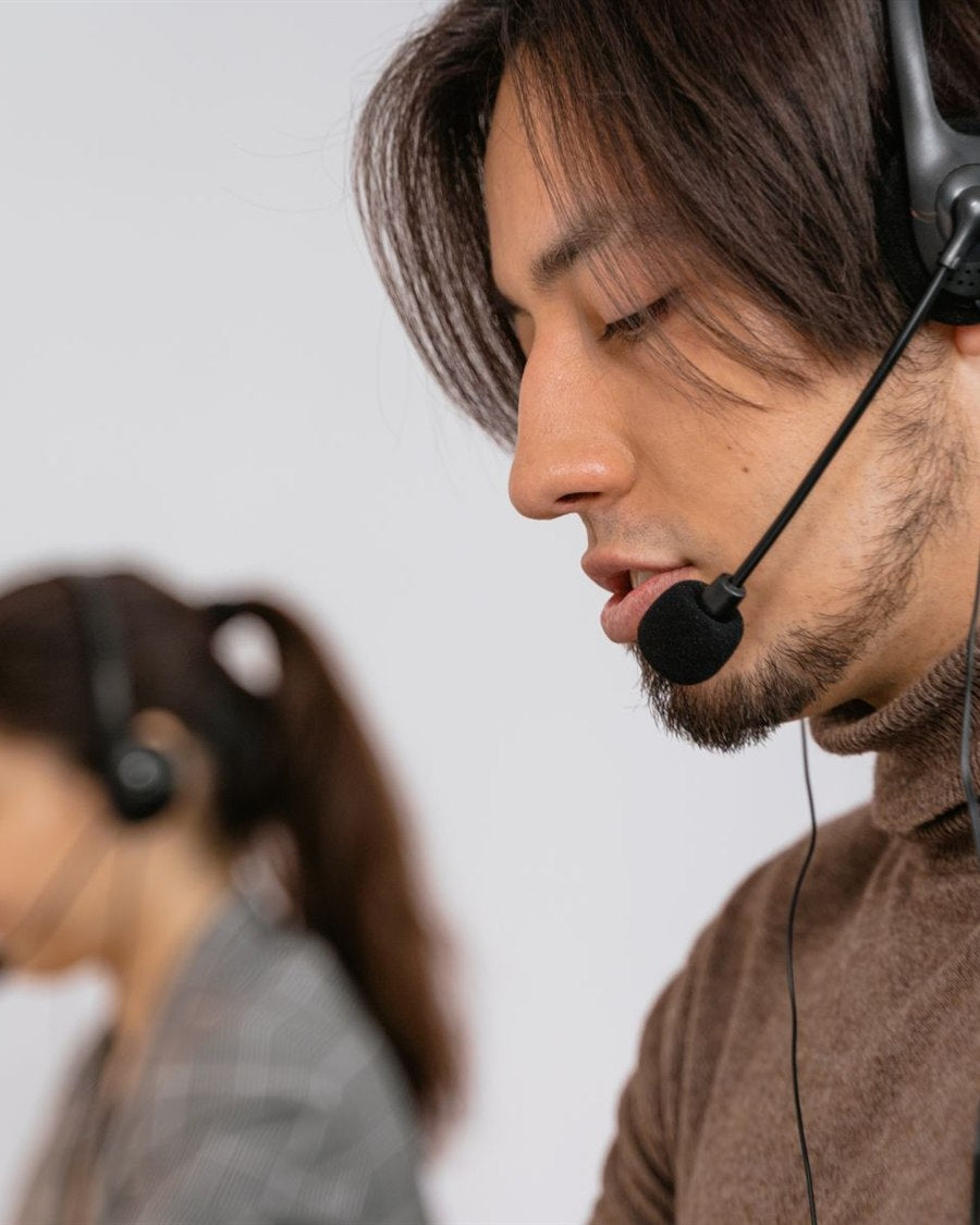 Customer service specialists wearing headsets at their desks