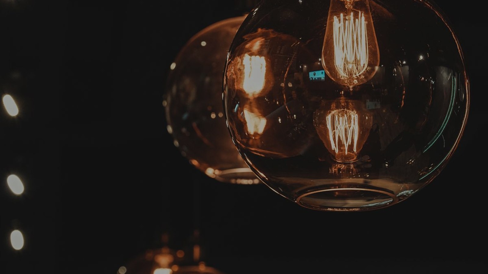 Amber glass globe pendants glowing in a dark interior