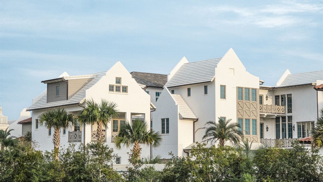 Row of white multi-unit residences under warm daylight